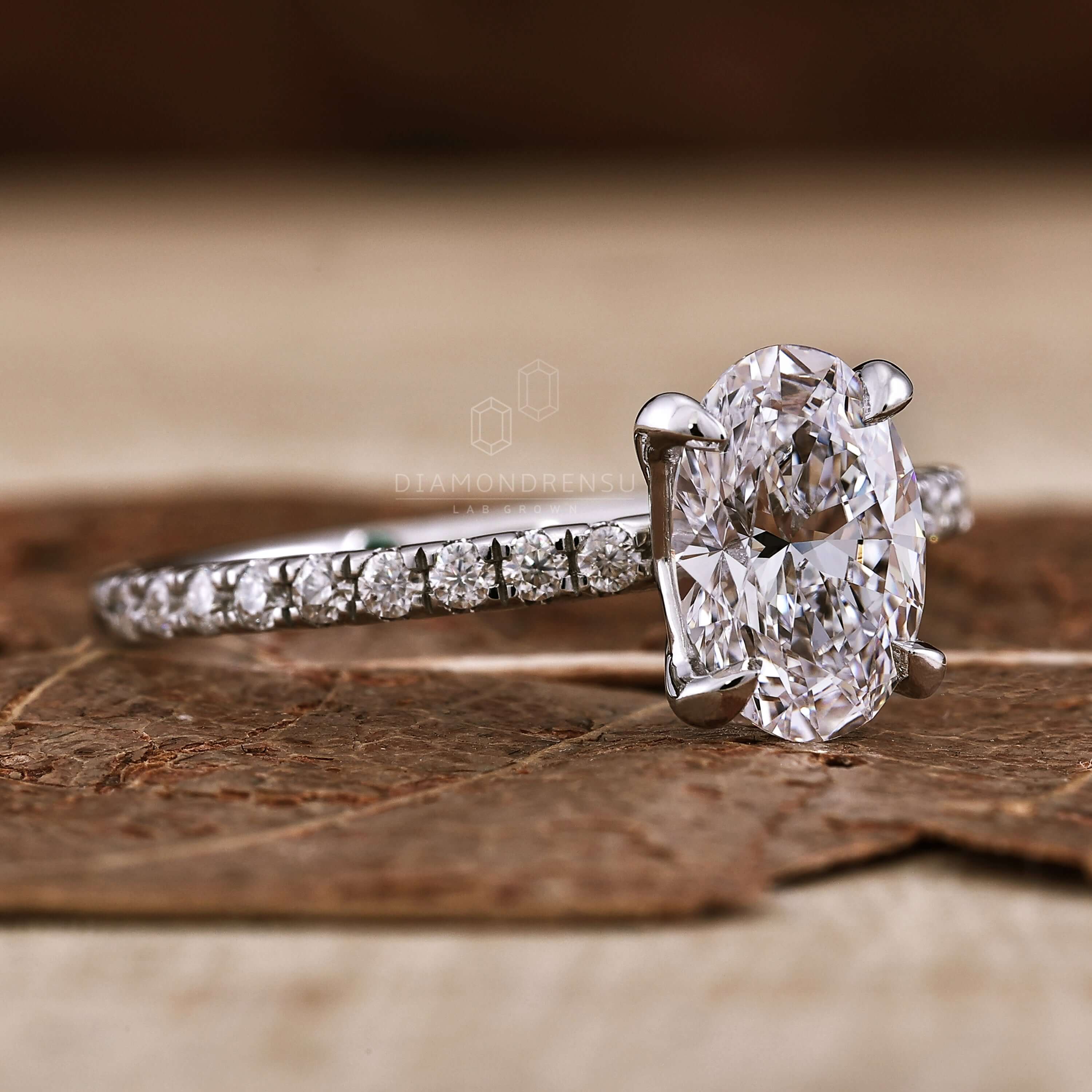 Oval diamond ring with pave diamond accents, designed for modern UK engagement ring styles.
