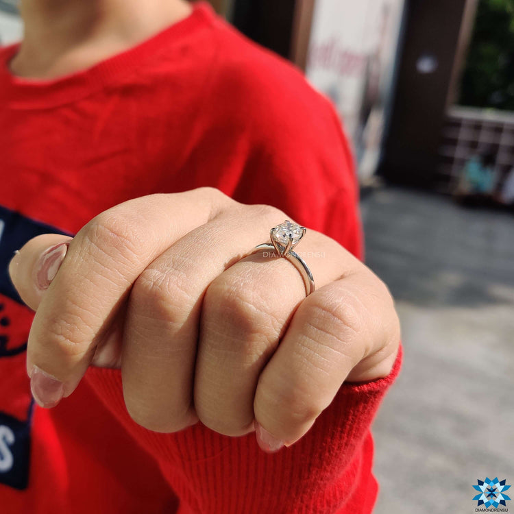 White gold oval moissanite ring secured with classic 4 claw prongs.
