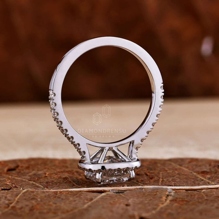 Cushion cut engagement ring with pave band detailing for elegance.
