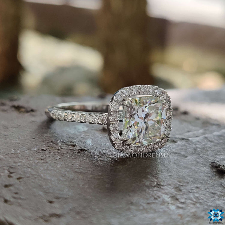 Pave setting ring featuring cushion Rensu moissanite and round side stones.
