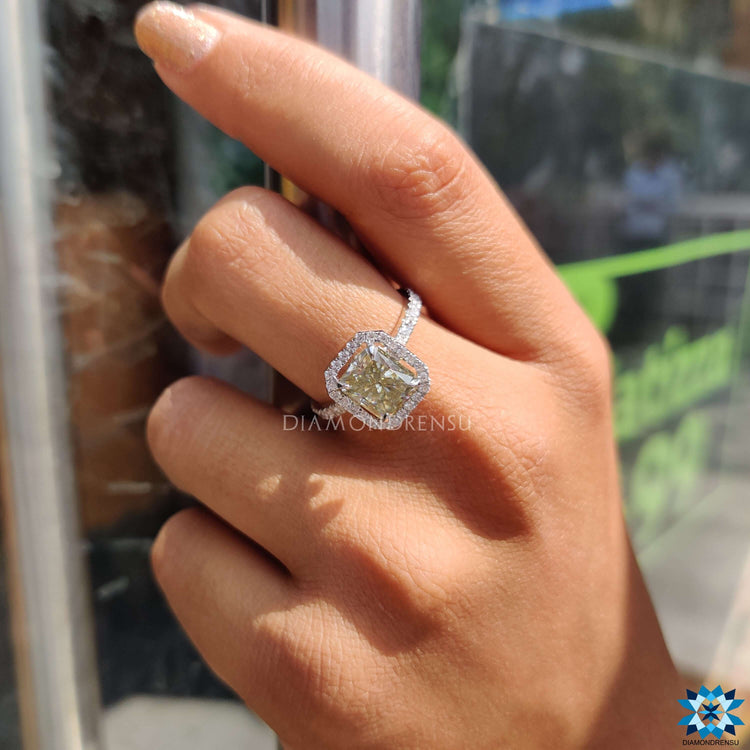 White gold moissanite ring in halo pave style with radiant cut centre.
