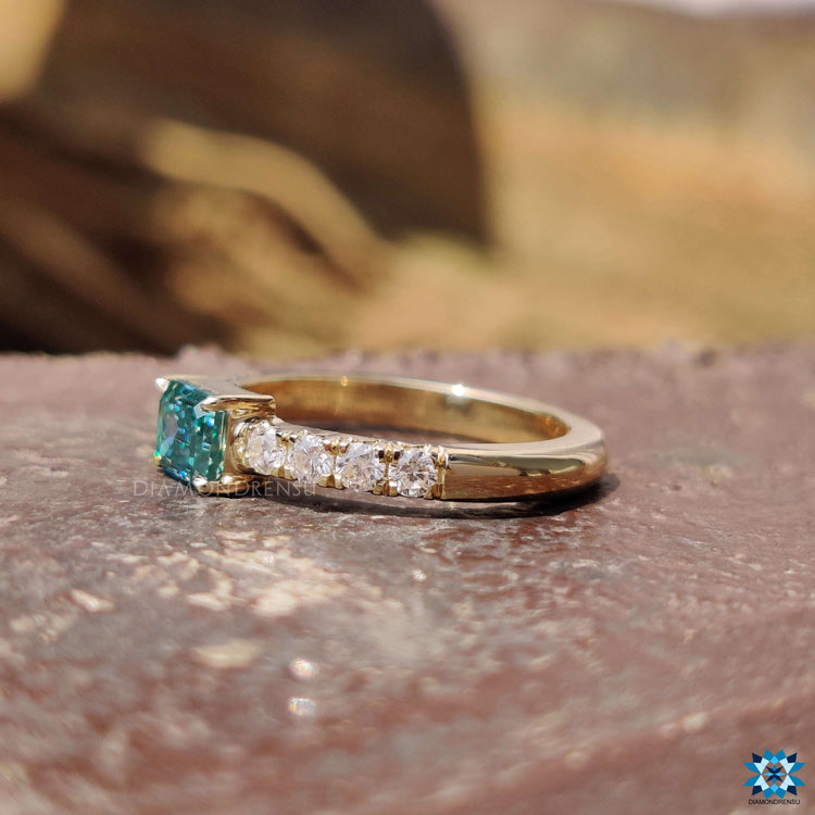 Emerald cut moissanite ring with pave setting.

