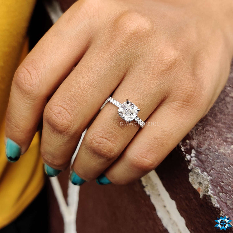 White gold moissanite ring with pave and tab prong setting.
