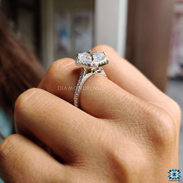 White and yellow gold halo engagement ring with gray moissanite.
