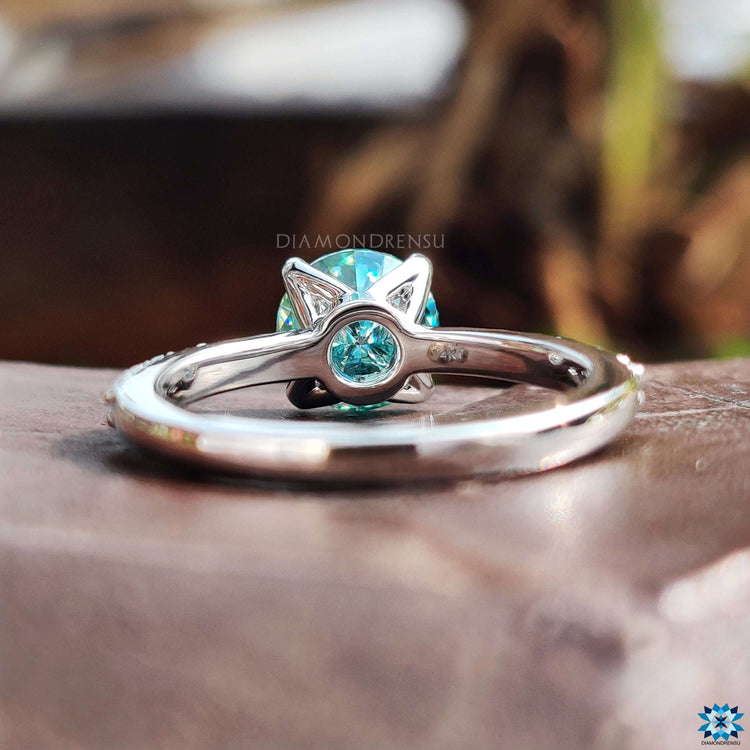 White gold moissanite ring with blue center stone.
