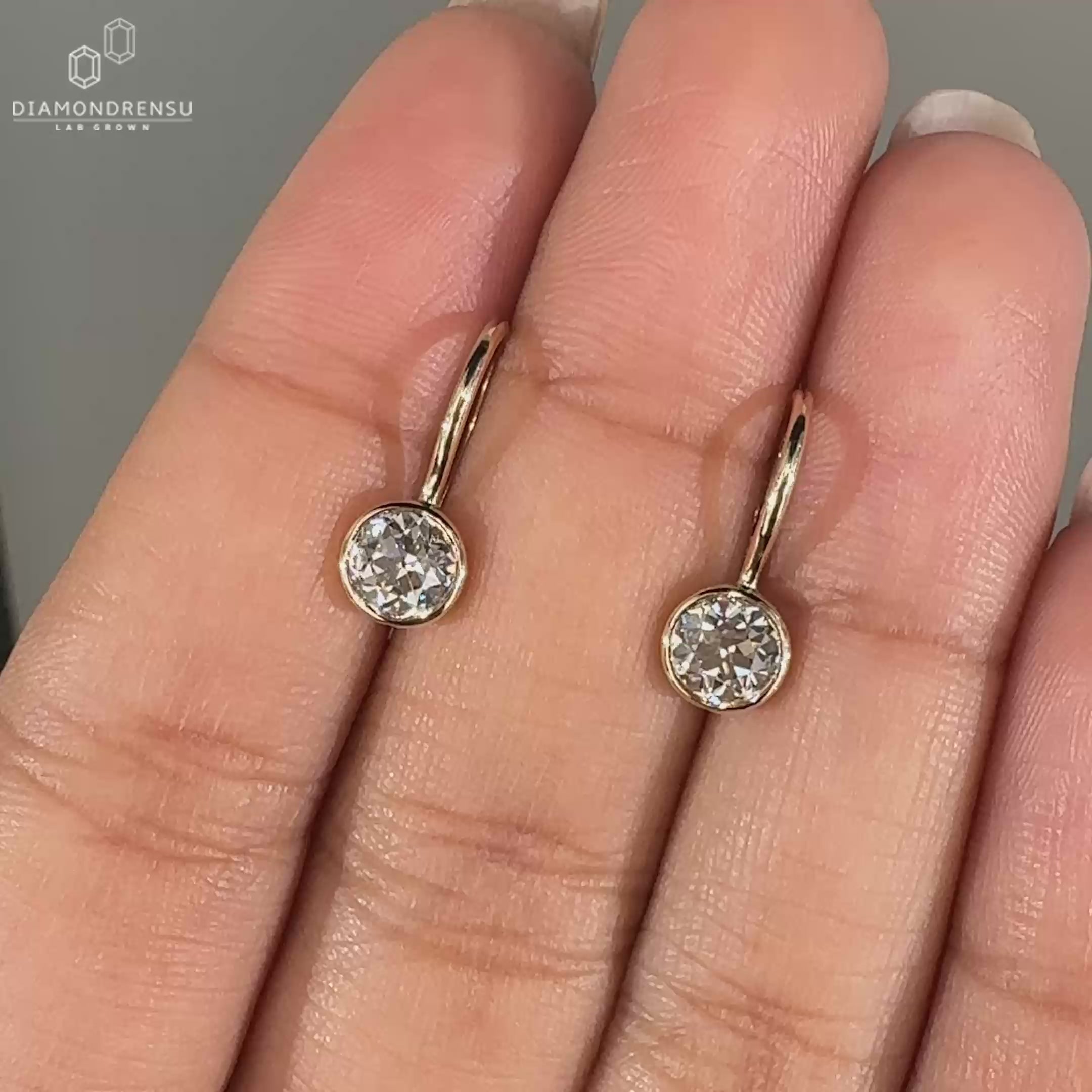 Bezel set diamond earrings in yellow gold.