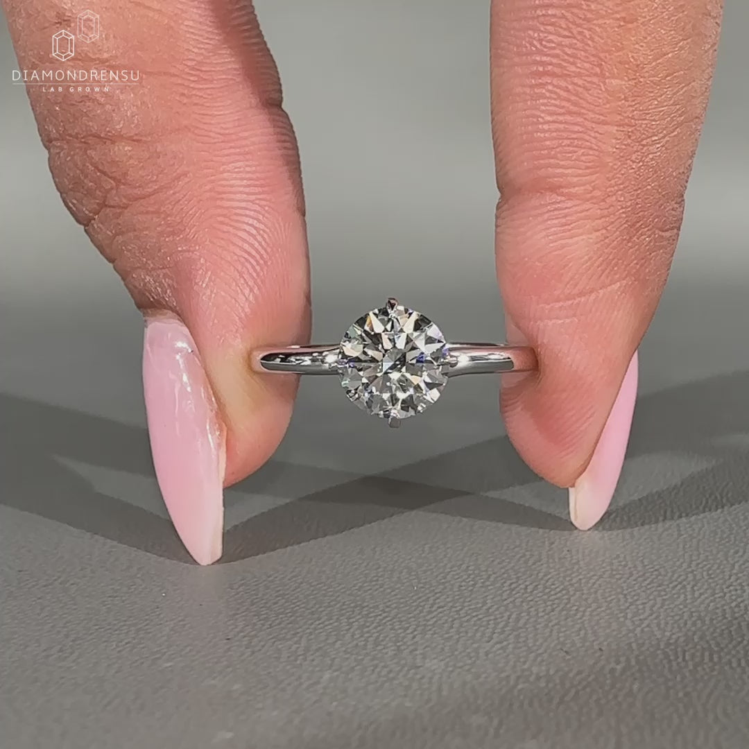Round diamond engagement ring set in compass prong setting.
