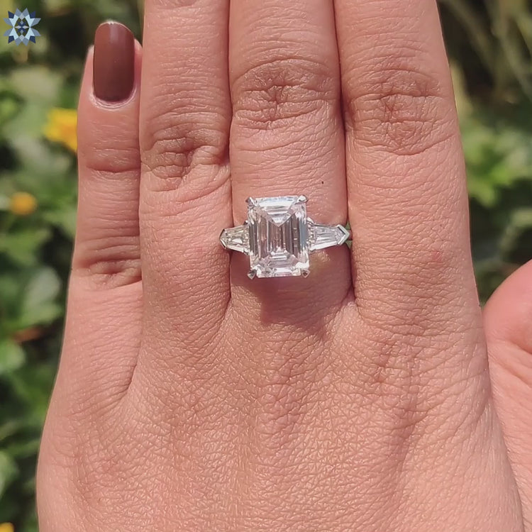 Handmade engagement ring with emerald moissanite and tapered bullet sides.
