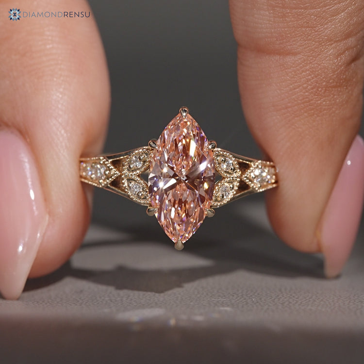 Pink marquise diamond ring with round side stones.