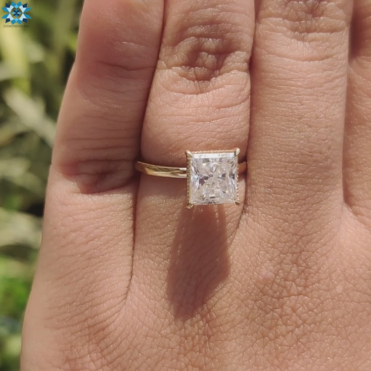 Custom moissanite ring with princess cut center and secure claw setting.
