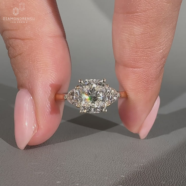 Cushion cut engagement ring with tapered shank and side stones.