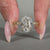 Yellow gold ring featuring round cut emerald gemstone and art deco design.
