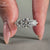 3 stone engagement ring featuring round diamond pave set design.
