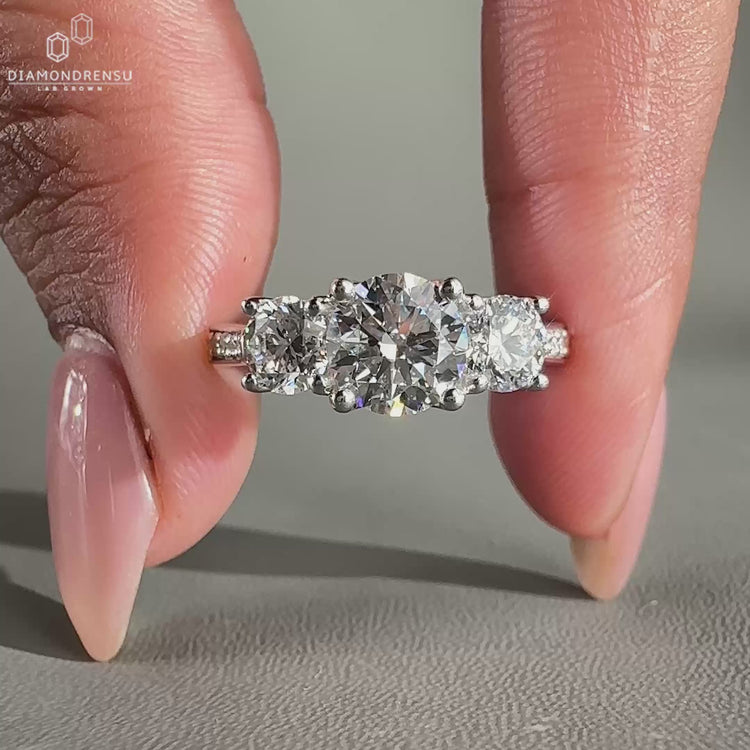 3 stone engagement ring featuring round diamond pave set design.
