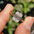 Hidden halo engagement ring featuring a solitaire design and tab prong setting.

