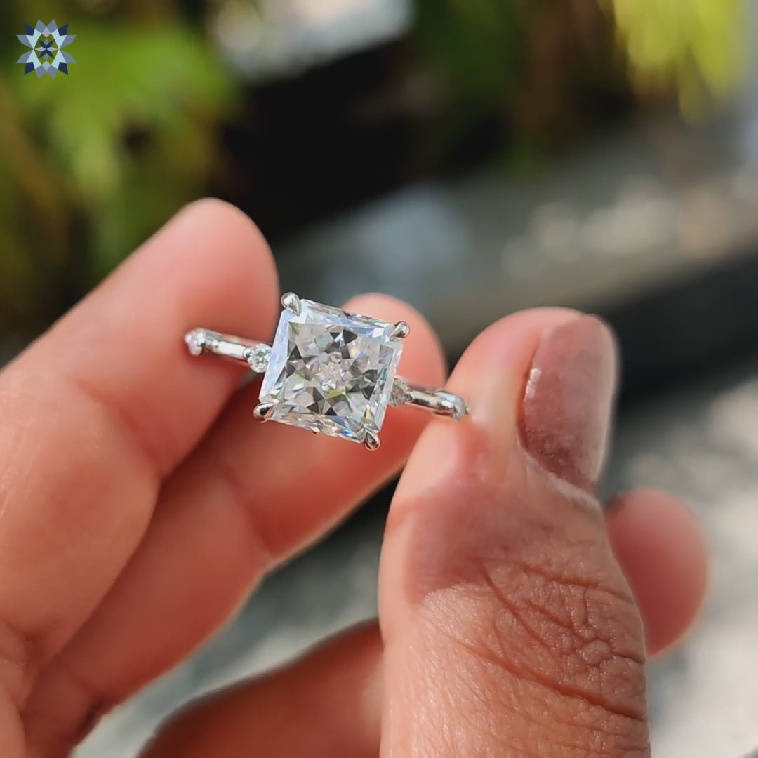 Radiant Rensu cut moissanite ring with white gold and pave band.
