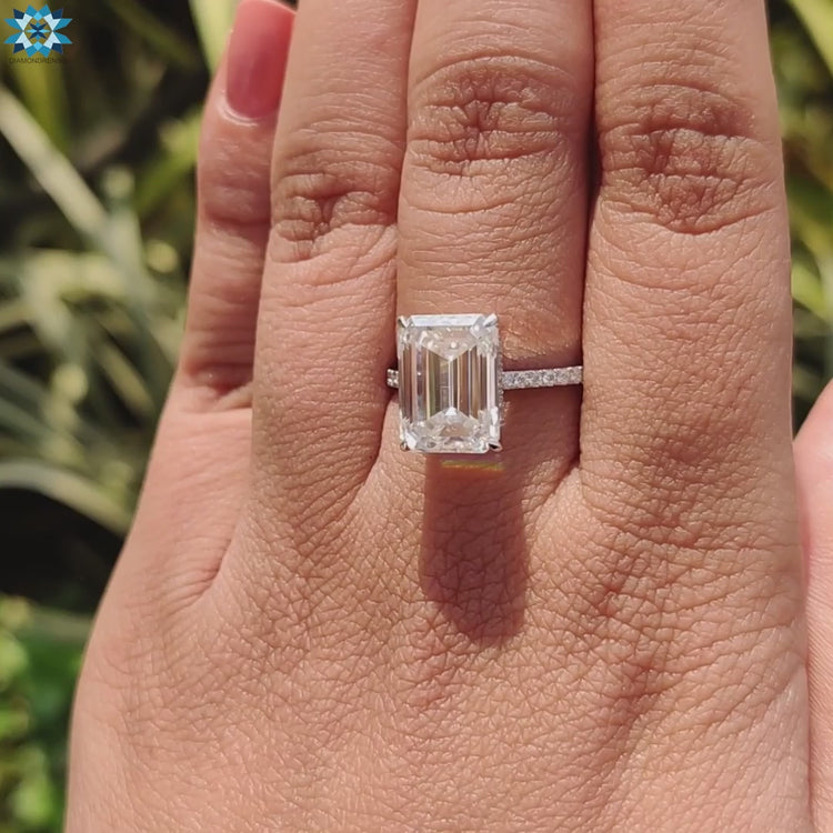 Handmade engagement ring in white gold with hidden halo under emerald cut.
