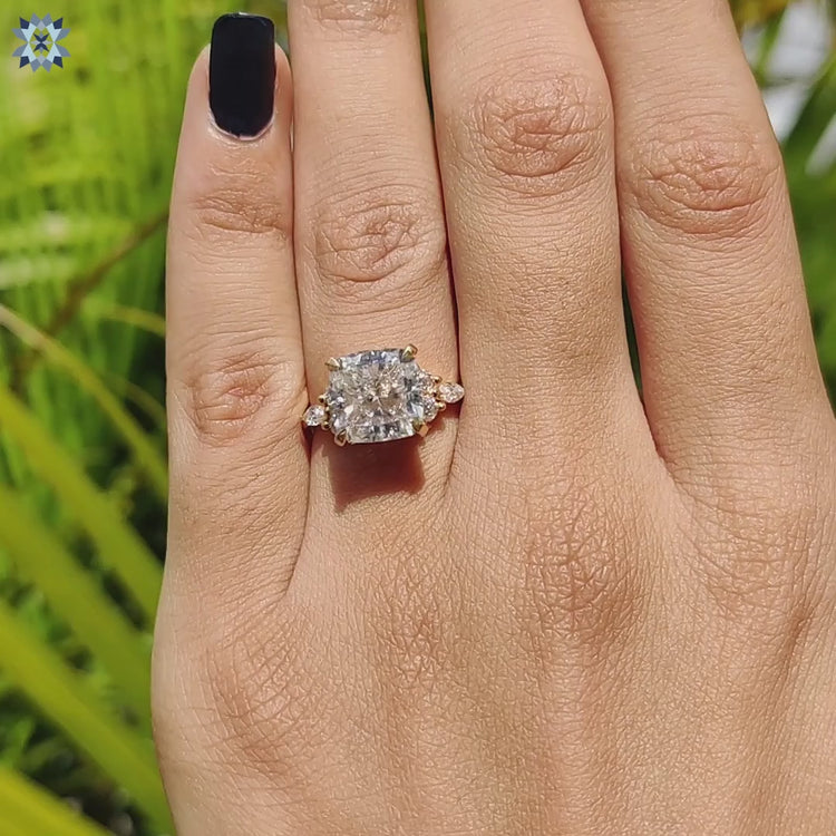 Round and marquise side stone ring with cushion moissanite in handcrafted yellow gold band.
