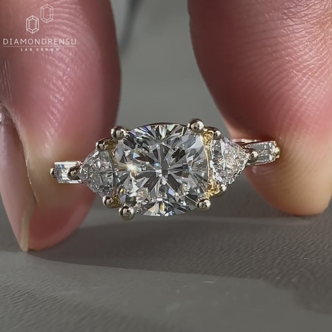 Cushion cut diamond ring with trillion side stones.
