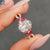 Hidden halo ring in rose gold featuring oval moissanite and round pave band.
