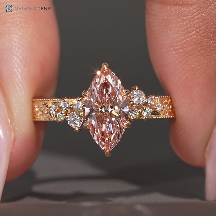 Pink centre diamond ring with round side stones.