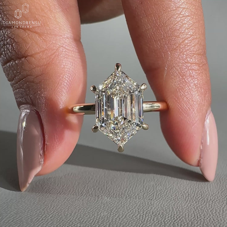 Hexagon diamond ring set in yellow gold with 6 prong claw setting.
