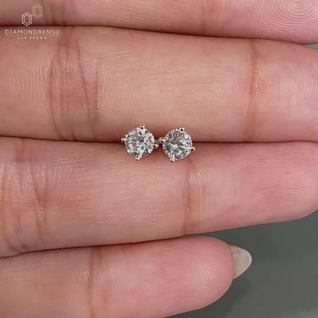 Round cut diamond earrings in yellow gold.