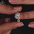 Princess cut ring includes hidden halo engagement ring design.
