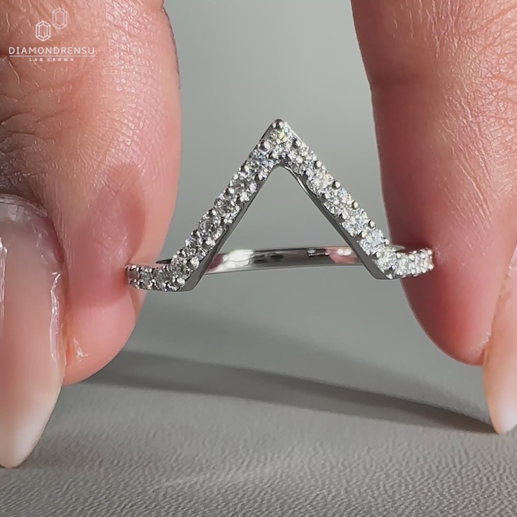 Round diamond wedding band featuring prong set lab grown stones.