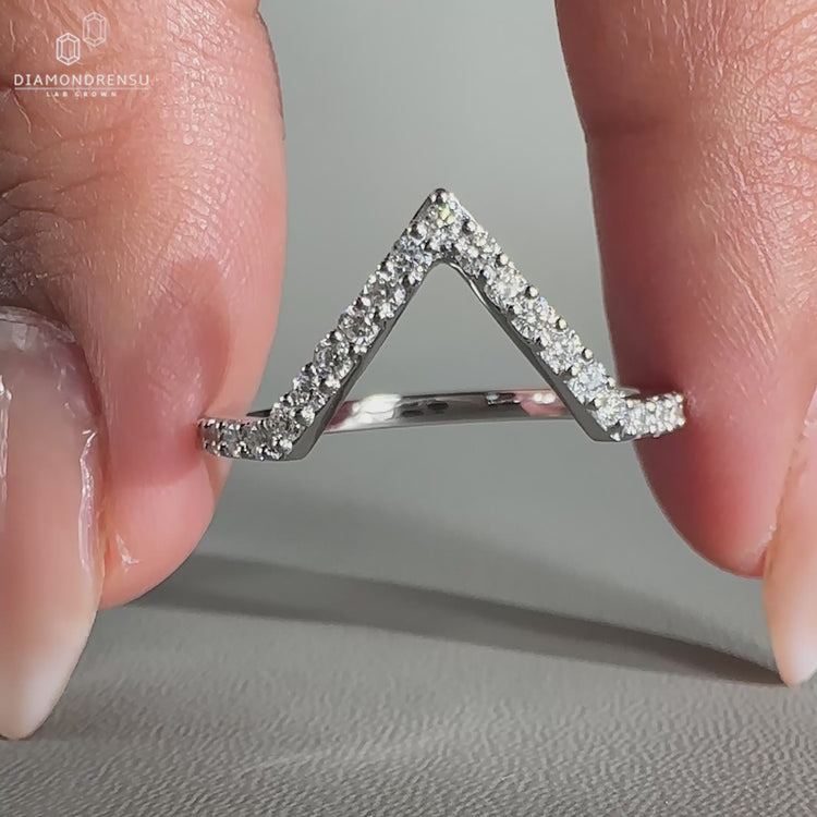 Round diamond wedding band featuring prong set lab grown stones.