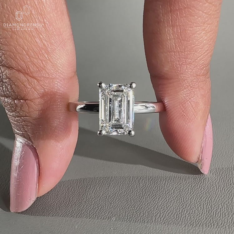 White gold emerald cut ring with an open gallery setting.
