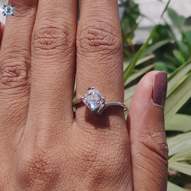 White gold ring with tension and prong set cushion moissanite.
