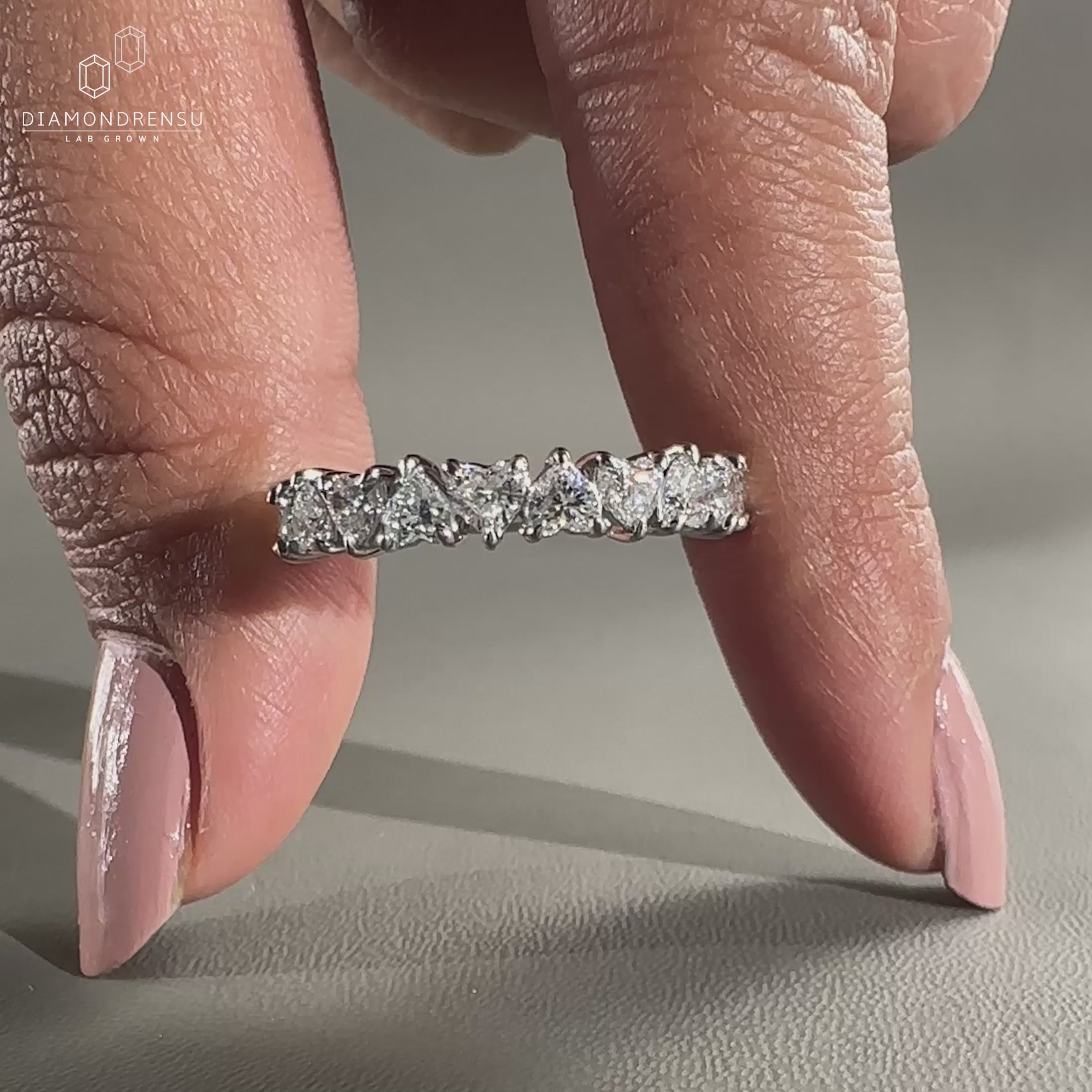 White gold wedding band with heart diamonds.
