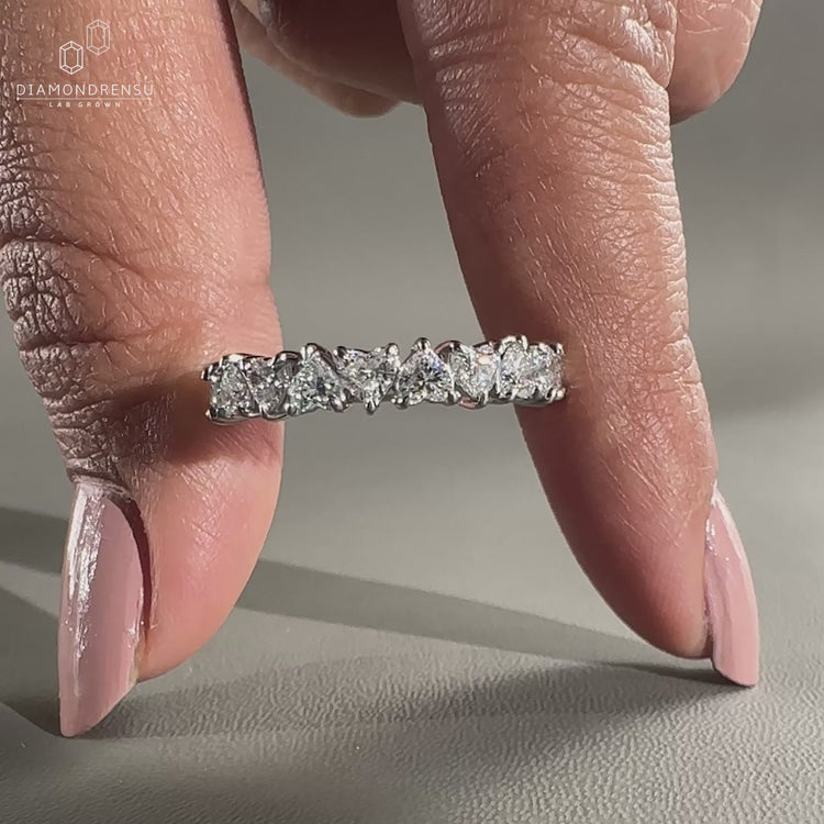 White gold wedding band with heart diamonds.
