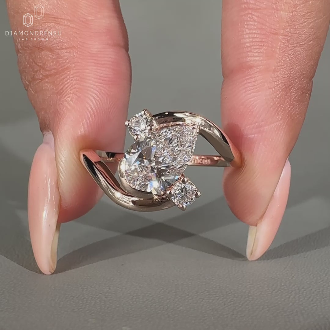 Pear cut diamond ring with round side stones.
