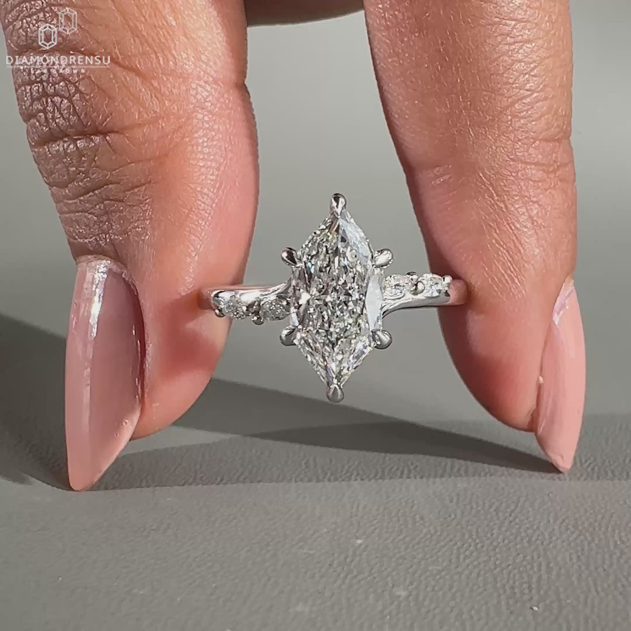 Marquise and round side stone on bridge accent ring setting.
