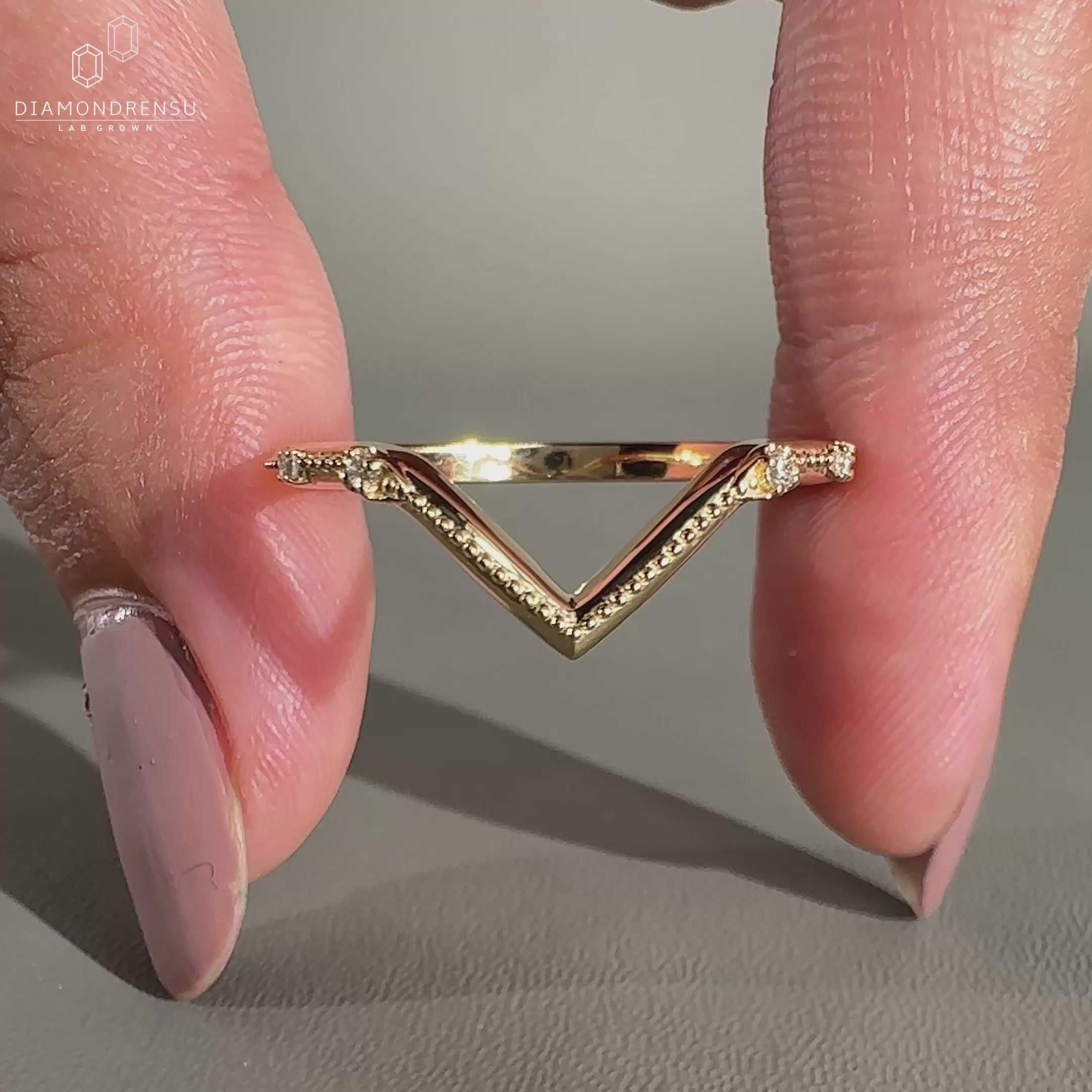 Gold V-shaped wedding band with diamonds.
