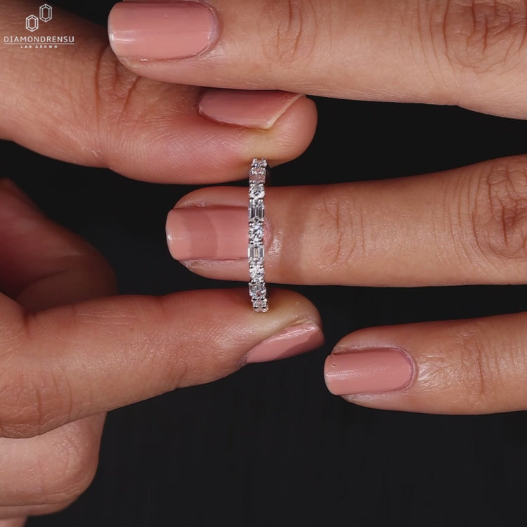 White gold wedding band with round and emerald diamonds.
