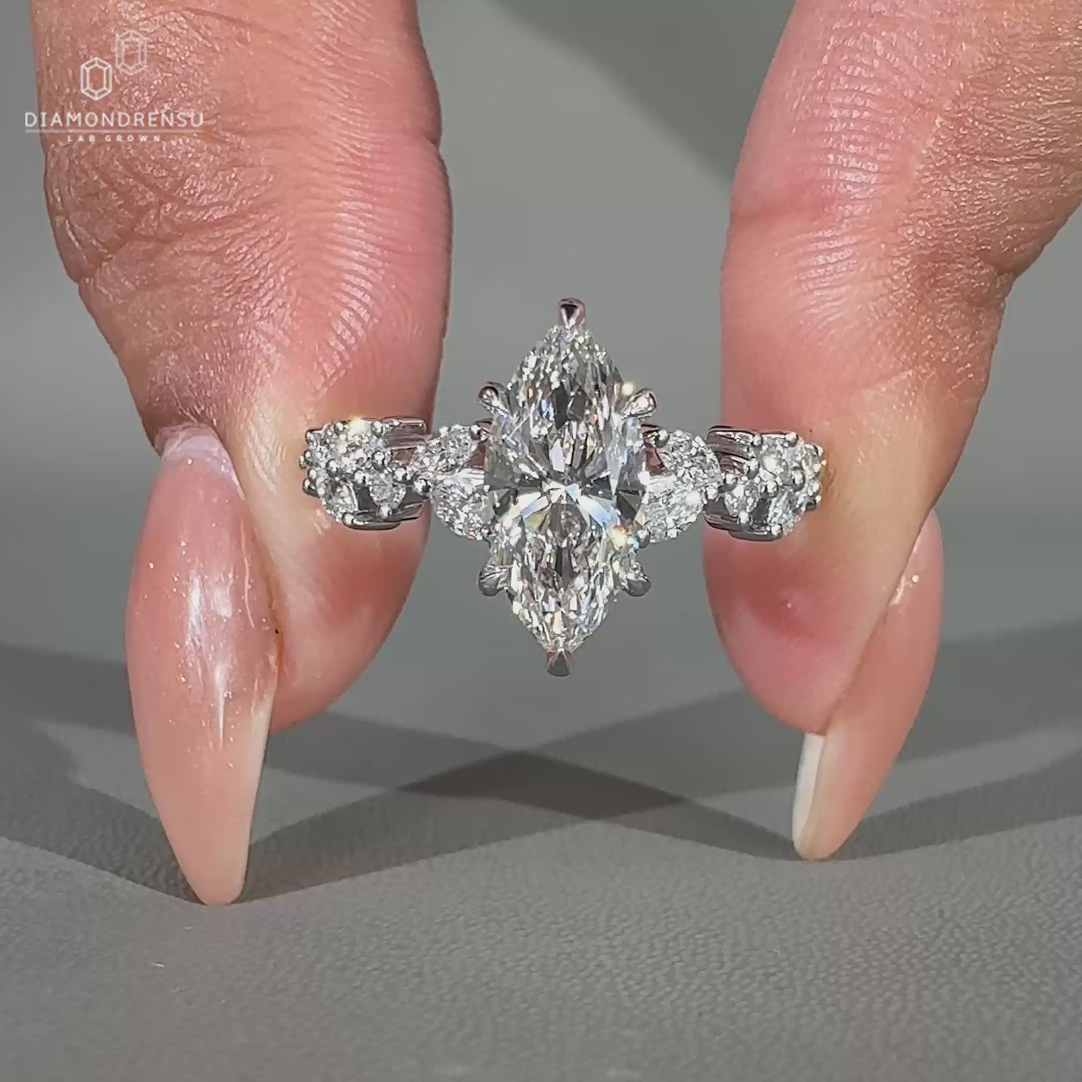 Marquise diamond engagement ring with six claw prong set and pave band.
