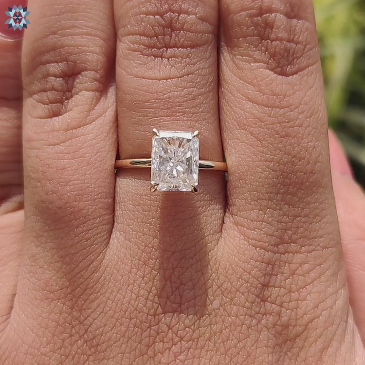 Yellow gold ring with radiant cut moissanite and 4 claw setting.
