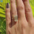 Solitaire ring featuring emerald cut moissanite in a classic gold band.
