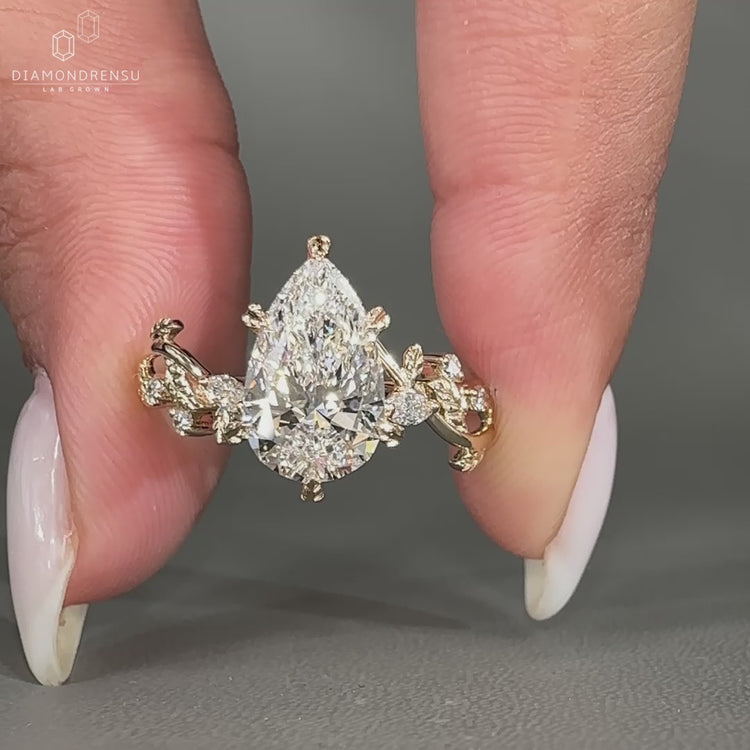Pear cut diamond ring with marquise and round diamond details.