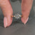 Round diamond ring with pear shape outline design.