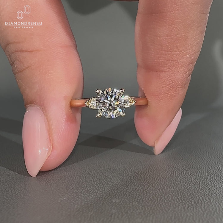 Round diamond ring with pear shape outline design.