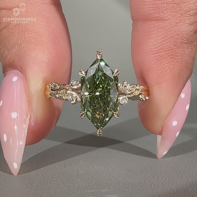 Art deco green diamond ring with six leaf prongs.