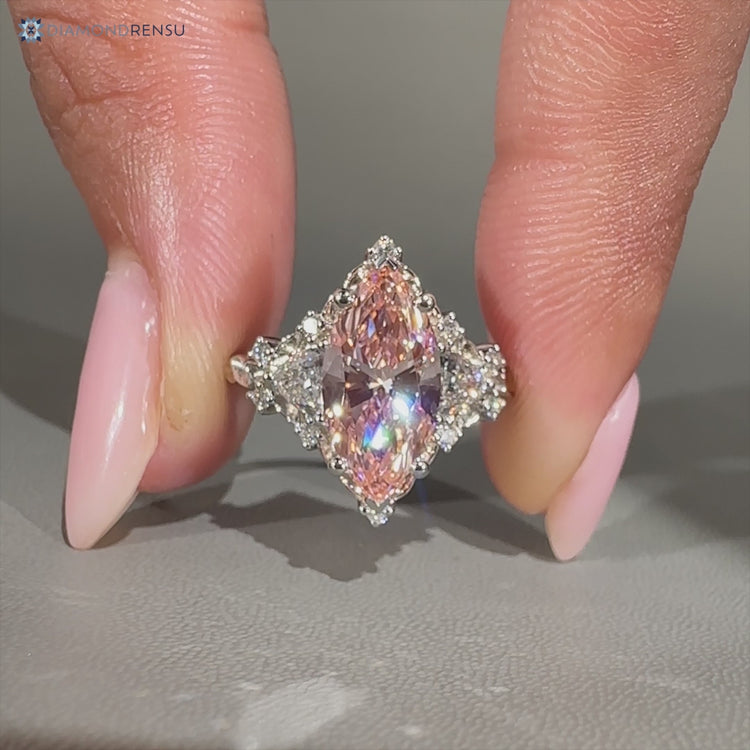 Pink marquise diamond ring with round and trillion stones.