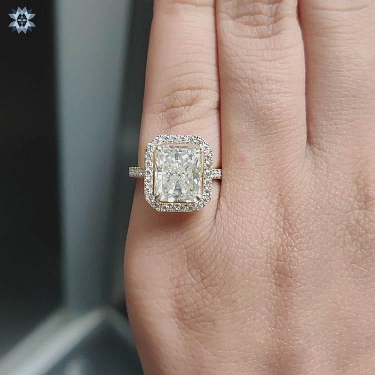 Radiant moissanite ring with hidden halo and pave setting in yellow gold.
