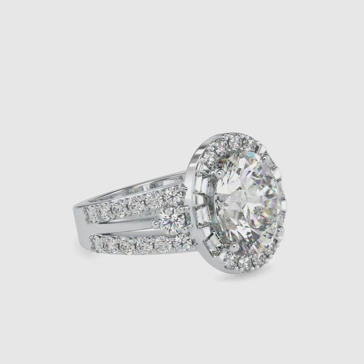Round side stone ring with oval diamond in yellow gold.
