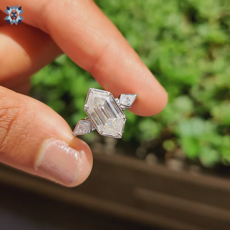 Three stone engagement ring with central hexagon and kite side stones.
