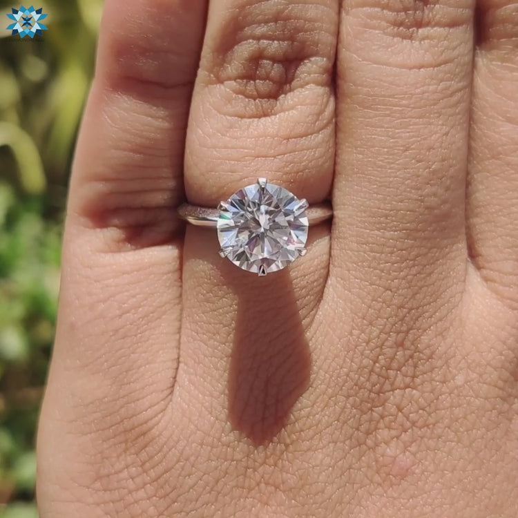 Round moissanite solitaire ring with prong setting.
